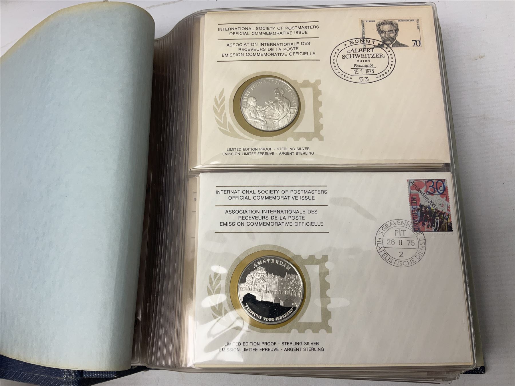 Thirty-six 'International Society of Postmasters Official Commemorative Issues' sterling silver proof medallic covers dating from 1975 to1977, housed in the official folder