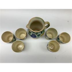 Early 20th century Royal Doulton Brangwyn Ware jug and set of six beakers, designed by Frank Brangwyn RA, all decorated in the Harvest pattern with stylised leaves and fruit on mottled peach and green ground, all with printed marks beneath, date code for 1920s, largest H18cm