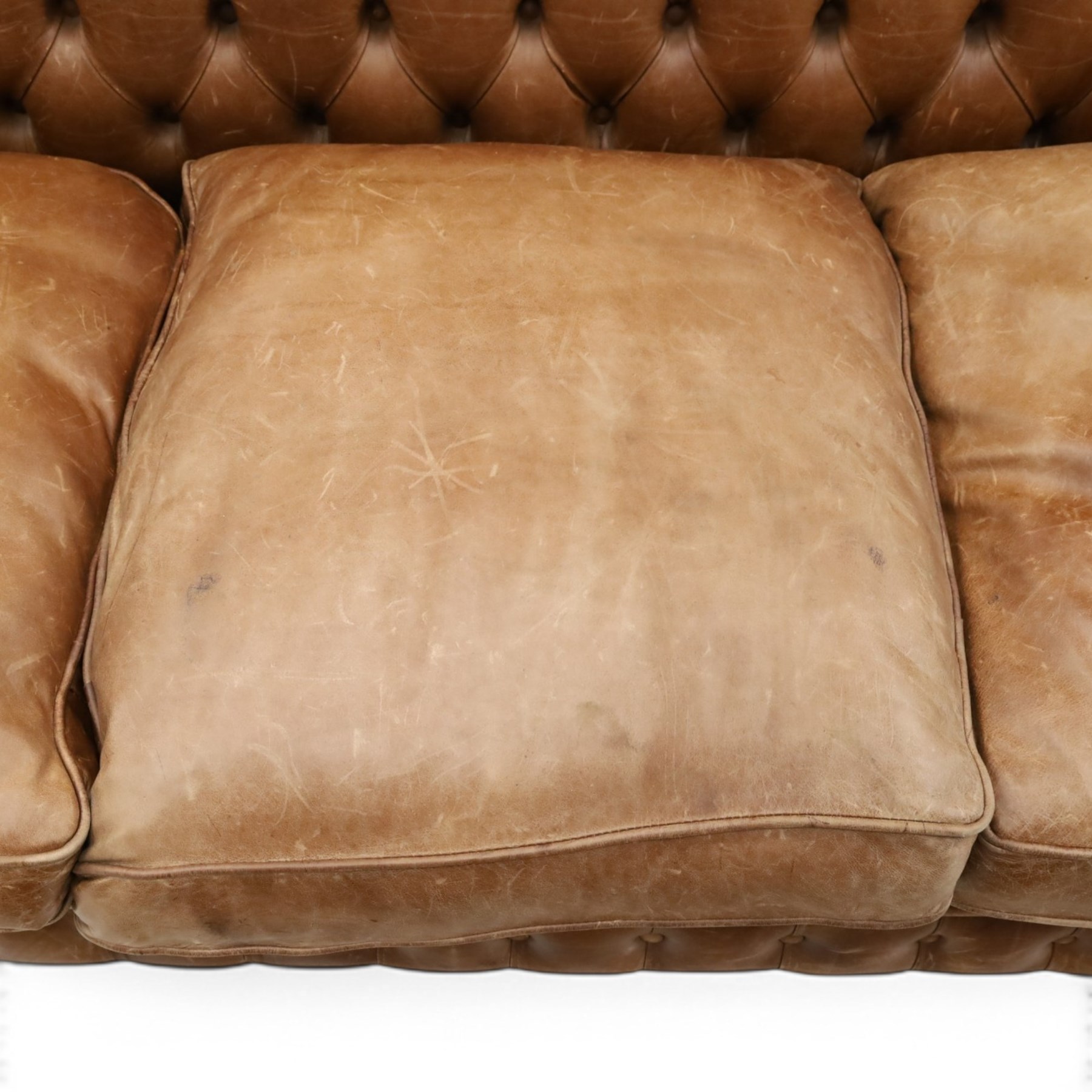 Fleming & Howland Ltd - large traditional shape four seater chesterfield club sofa, the rolled ack and arms with studwork, upholstered in buttoned tan leather with loose seat cushions, raised on large turned feet