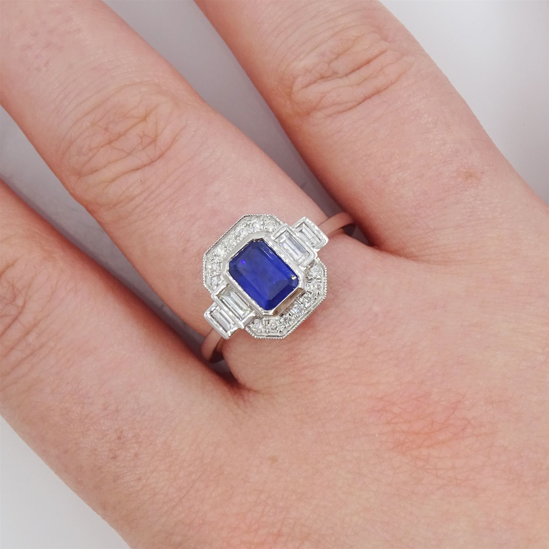 Platinum sapphire and diamond ring, single octagonal cut sapphire of approx 1.15 carat, flanked by two baguette cut diamonds and milgrain set round brilliant cut diamond surround, hallmarked, total diamond weight approx 0.35 carat