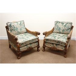  Early 20th century walnut framed bergere suite, the acanthus carved outsplayed arms with double caned sides, scroll and leaf carved frieze on cabriole legs with claw and ball feet, with loose back and seat cushions, comprising Sofa, W202cm, H94cm, D93cm, Two chairs, W80cm, H94cm, D93cm, Stool, W71cm, D42cm, H38cm,   