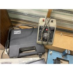 Six shelved cabinets for displaying ‘00’ gauge locomotives comprising plain plywood and white painted examples with track applied to various shelves, largest H63cm, W107cm, D27cm; Collection of tools for building model locomotives to include Weller PU-2D Soldering Pencil and Standard Tip Soldering Iron 20W/230V, Humbrol Modellers Airbrush, Power Supply Units and two wooden chests one of which housing a collection of tools including tweezers, scalping tools, wrenches etc 