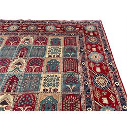 Persian Bakhtiari crimson ground carpet, the field divided into seventy panels decorated tree of life motifs, mihrabs and stylised plants, the border decorated with repeating circular medallions formed of Hac motifs, floral pattern guard stripes 