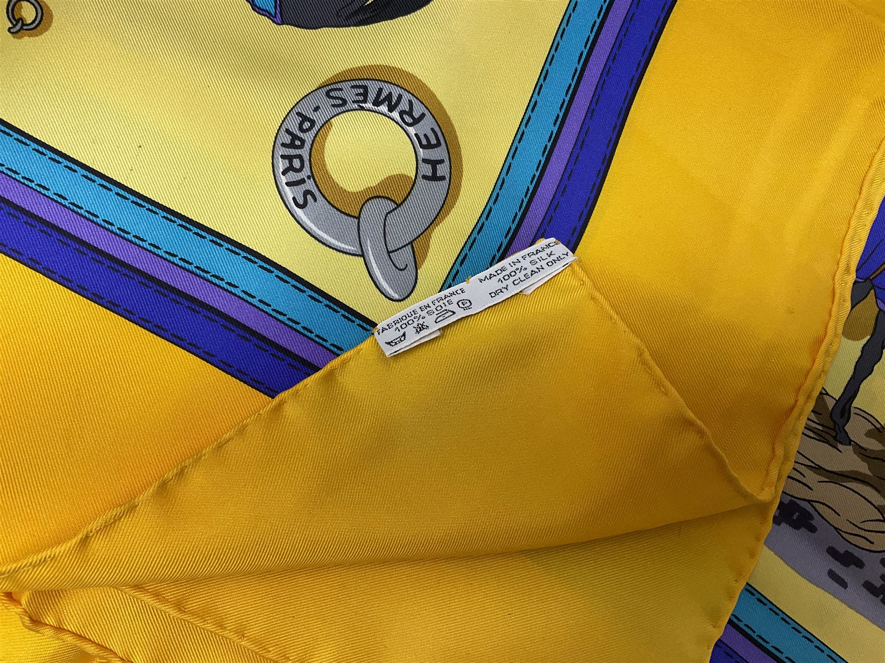 Hermès 'Ecuries' silk scarf, designed by Hugo Grygkar in 1947, printed with twenty horses in their respective stables, on yellow ground contained within stitched effect blue and purple and darker yellow gold borders, with rolled hand stitched edges and Hermes material label, 87cm square