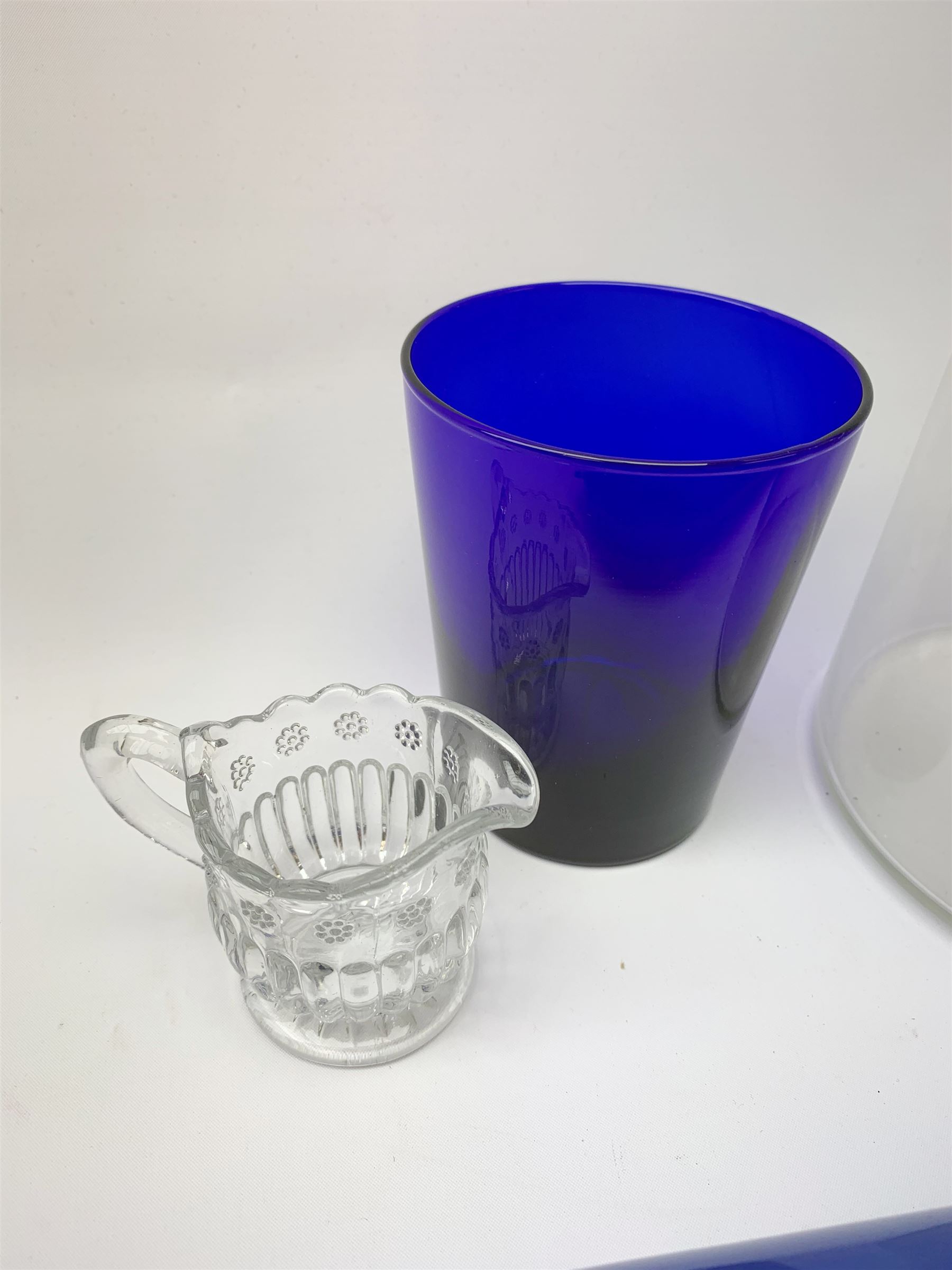 Two Victorian glass rolling pins, the larger blue example inscribed 'Remember Me' between floral sprays, largest L33.5cm, together with a late Victorian clear glass jug, H24cm, Bristol Blue type tumbler, and small moulded cream jug. 