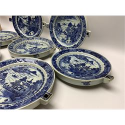 Set of seven late 18th/early 19th century Chinese export blue and white hot water plates, decorated with landscape set with pagoda, islands, bridge, and two figures within a white reserve, within spearhead and foliate borders, W28cm