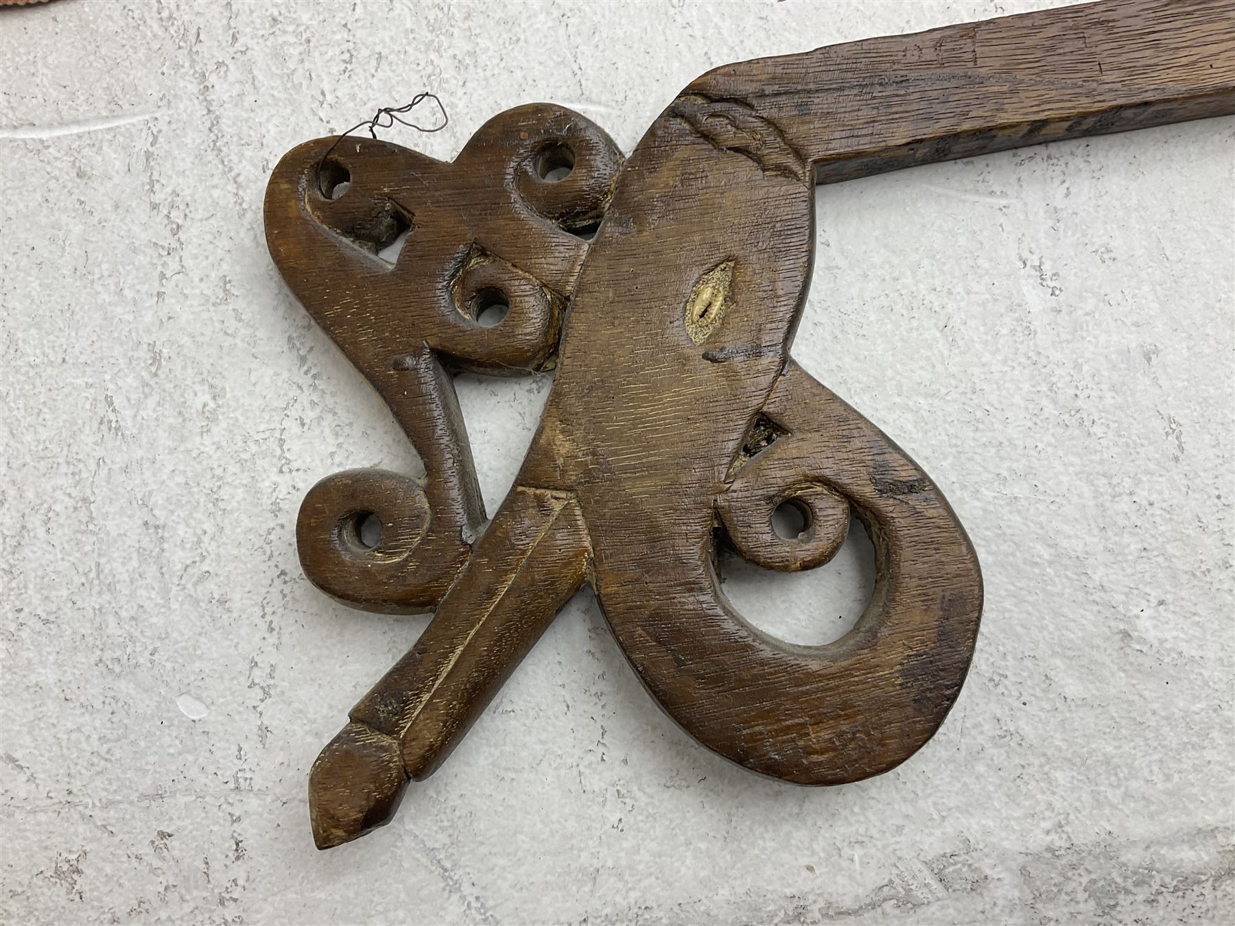 Ikat Man’s Cloth (Hinggi Kombu), East Sumba, Indonesia, woven in red, blue and yellow-brown warp ikat, constructed of two mirroring long panels, the motifs arranged in four bands depicting warrior figures astride rearing horses, high-ranking figures and guardians within geometric borders, on carved wooden wall hanger, L295cm
