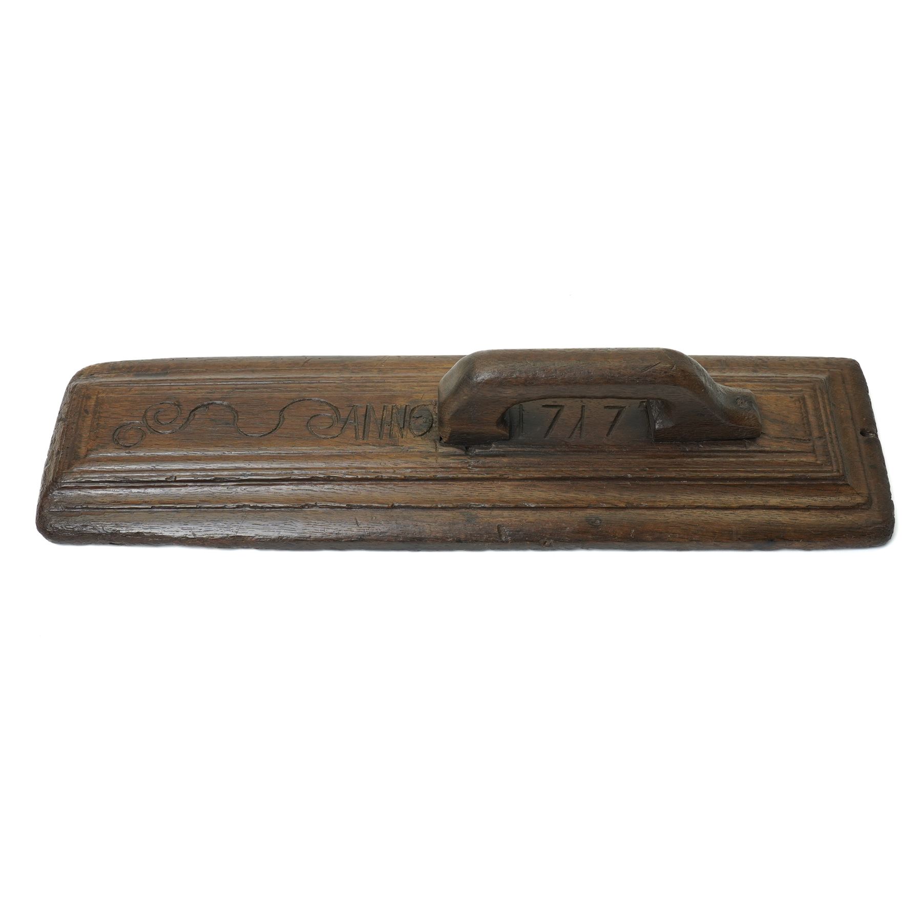 18th century oak mangle board, carved with scrolled motifs, incised 'ANNO 1717', W57cm 