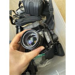 Collection of cameras and camera equipment, including Voigtlander Vitomatic I, Nikon Coolpix P340, Nikon Coolpix S9100, Olympus SP-510UZ, tripod, cases, etc