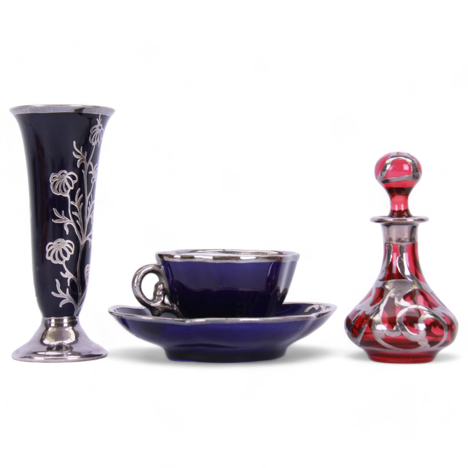Cranberry glass scent bottle with silver overlay, together with German fluted vase with silver overlay upon a blue ground and similar teacup