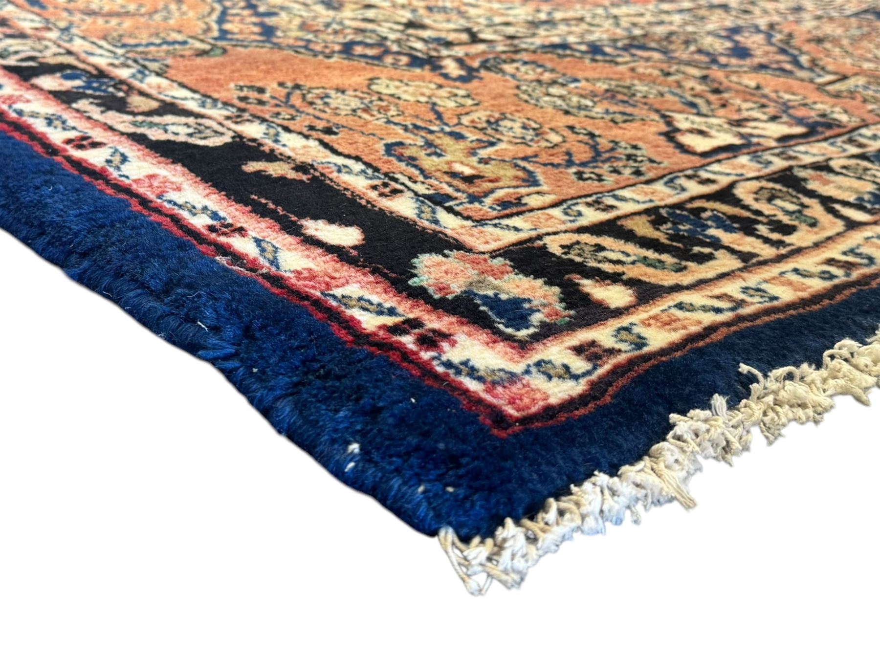 Persian Herati design indigo and red ground carpet, decorated with floral motifs, arched border