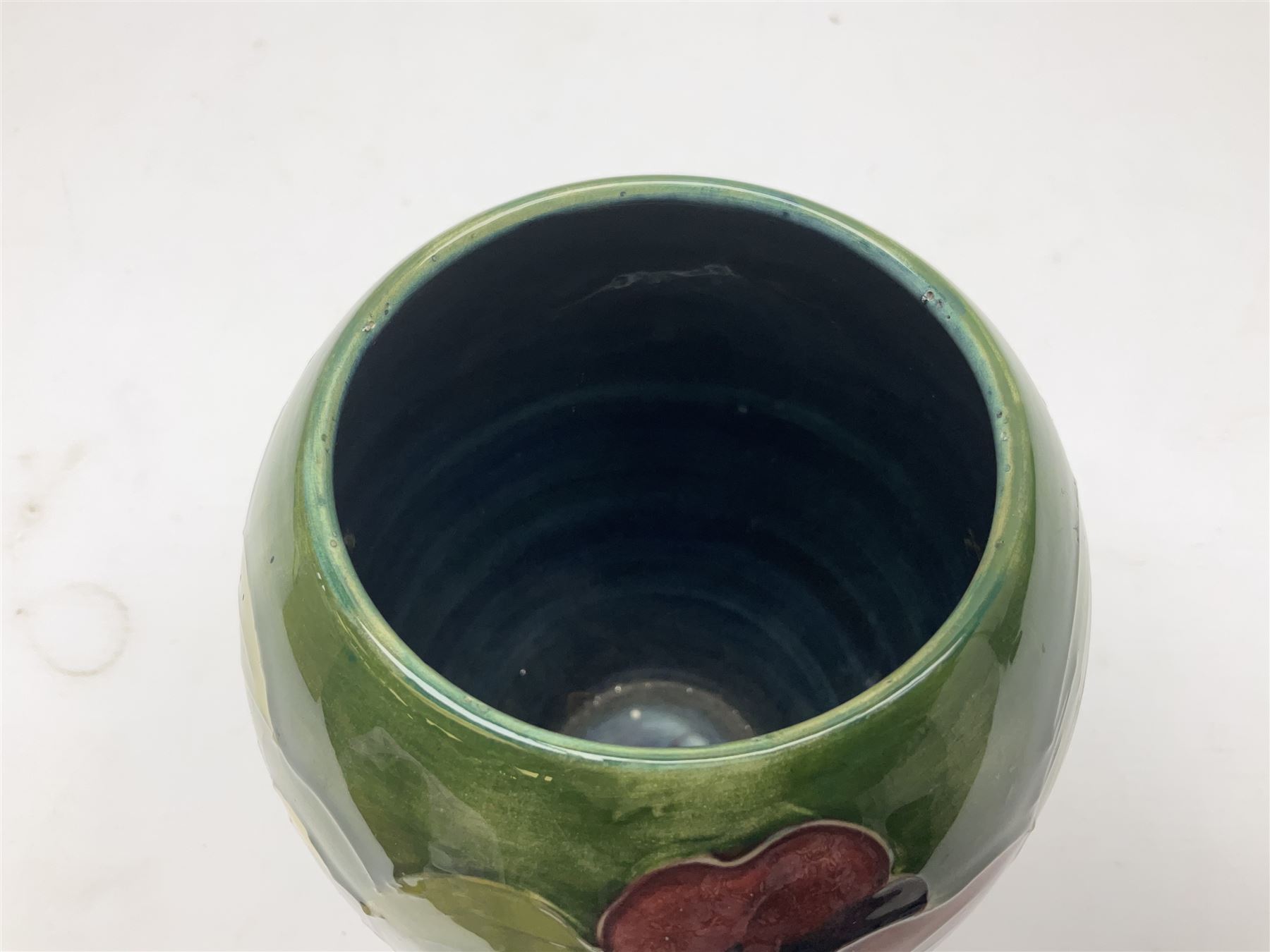 Moorcroft Hibiscus pattern vase of ovoid form, decorated with pink, yellow and purple flowers on merging blue and green vase, with impressed and painted marks beneath, H18cm