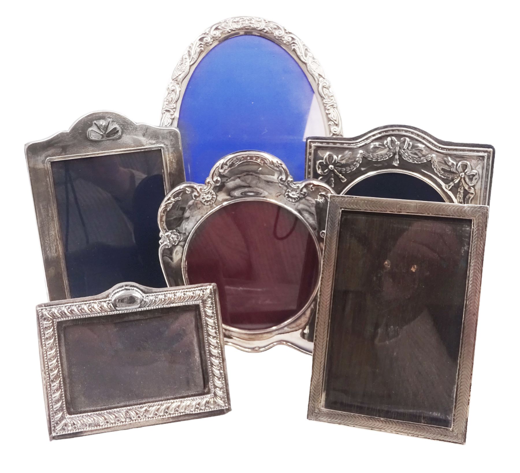 Six modern silver mounted photograph frames, to include an oval example, decorated with doves and green man masks, hallmarked W I Broadway & Co, Birmingham 1985, and a rectangular example with crossed golf club decoration, hallmarked Carr's of Sheffield Ltd, Sheffield 1994 etc, largest H24cm