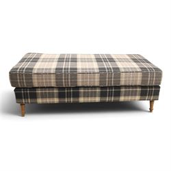 Large traditional design upholstered footstool, upholstered in checked fabric, with loose cushion, raised on a light turned supports 