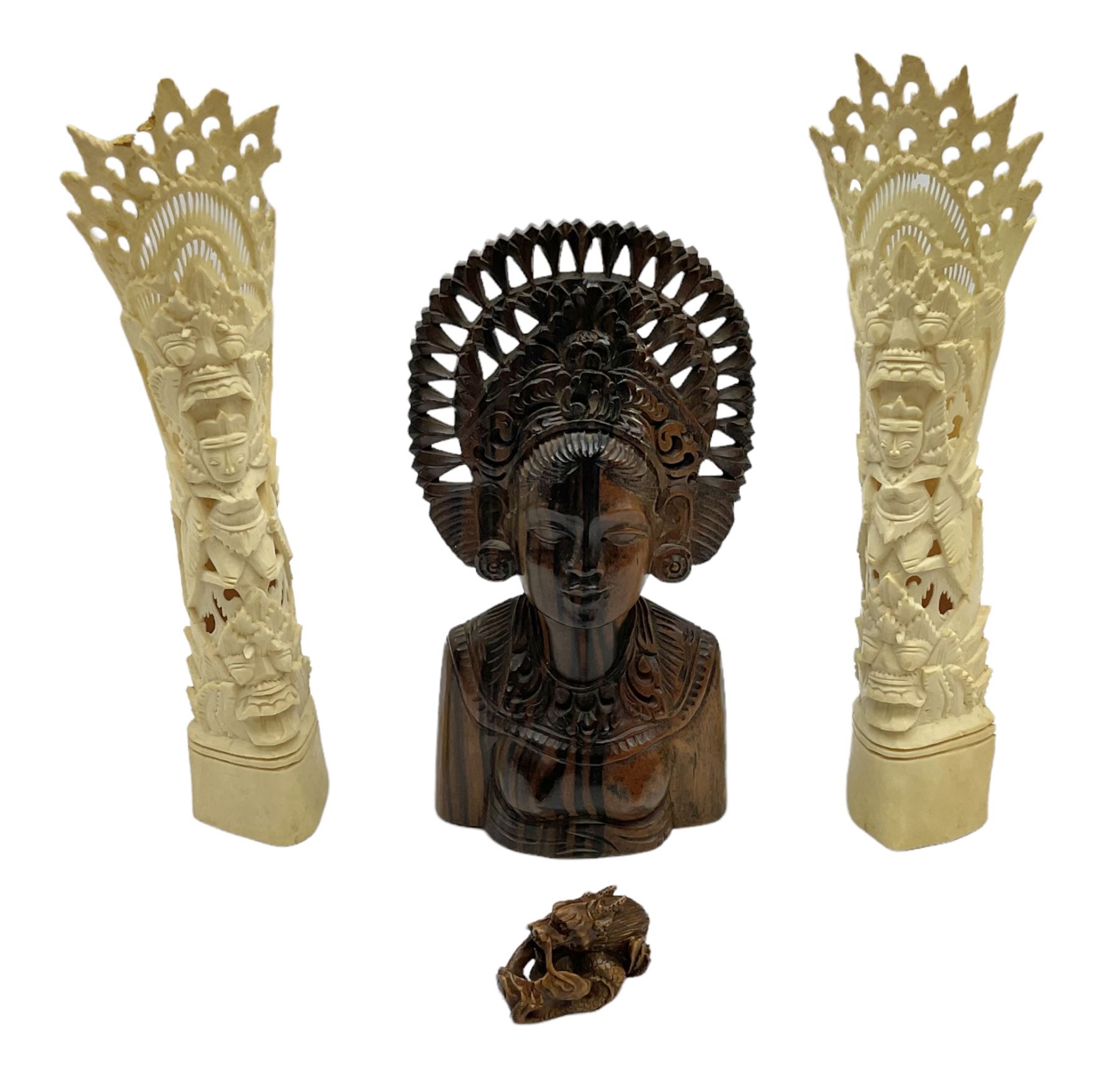 Hardwood bust of an Indoniesian Goddess, carved wearing a pierced headdress, from Klungkung, Bali, H20cm, together with a pair of bone carvings of deity figures, and a carved wood Netsuke in the form of a Chinese dragon