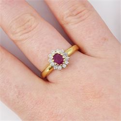 18ct gold ruby and diamond cluster ring, single oval cut ruby of approx 0.25 carat, surrounded by twelve round brilliant cut diamonds, hallmarked, total diamond weight 0.25 carat