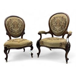 Pair of Victorian walnut lady's and gentleman's drawing room chairs, arched cresting rail carved with cartouche and extending foliage, upholstered in floral pattern fabric, on foliate carved cabriole feet