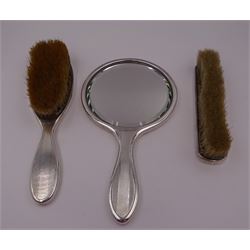 1920s Britannia silver mounted three piece dressing table set, comprising hair brush, hand mirror and clothes brush, each with vertical engine turned decoration, the brushes engraved with moon phases to top edge, hallmarked British Metallising Co Ltd, London 1928