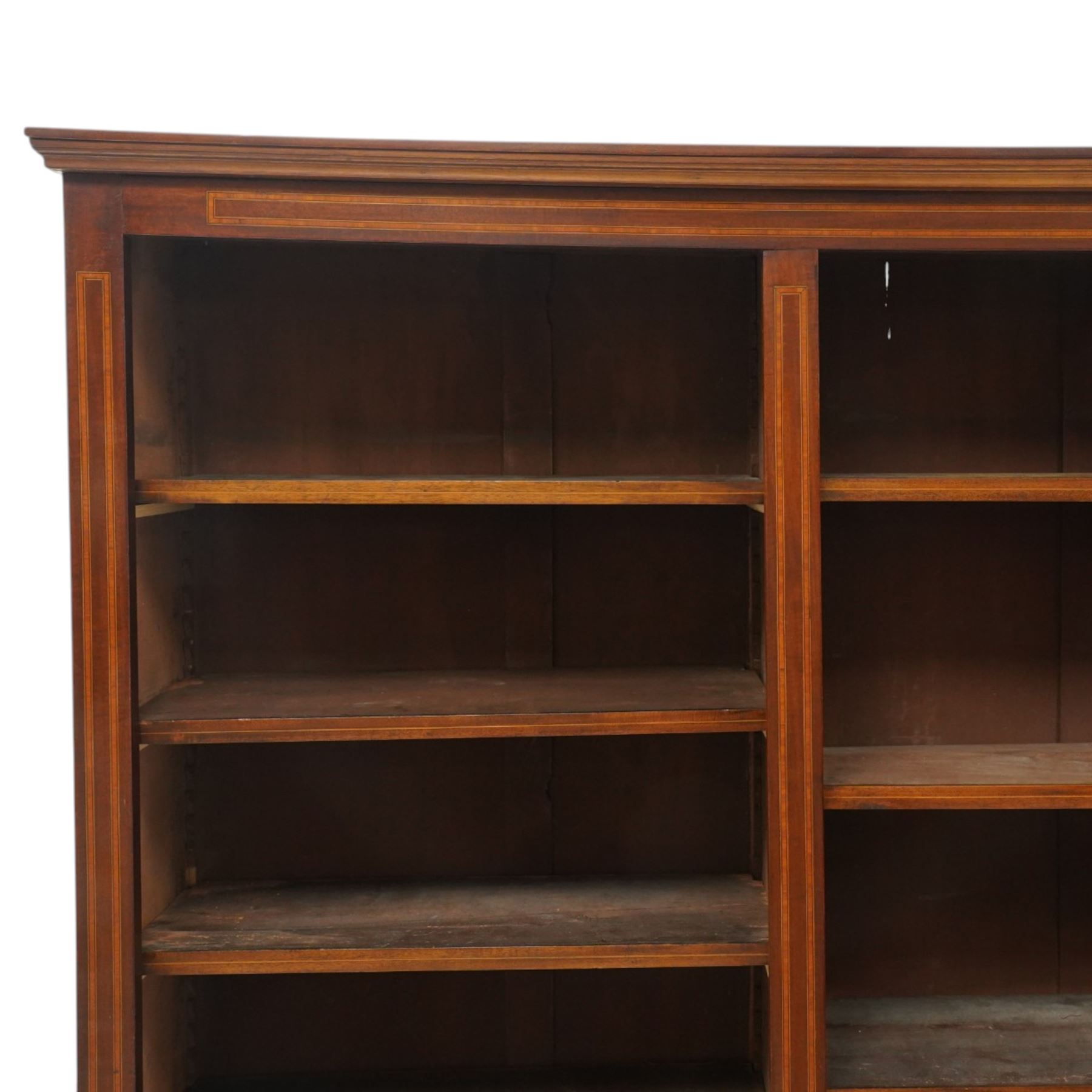 Quality Edwardian inlaid mahogany triple-column open bookcase, projecting cornice over a satinwood banded frieze, fitted with fourteen adjustable shelves with strung facias, the shaped apron on bracket feet