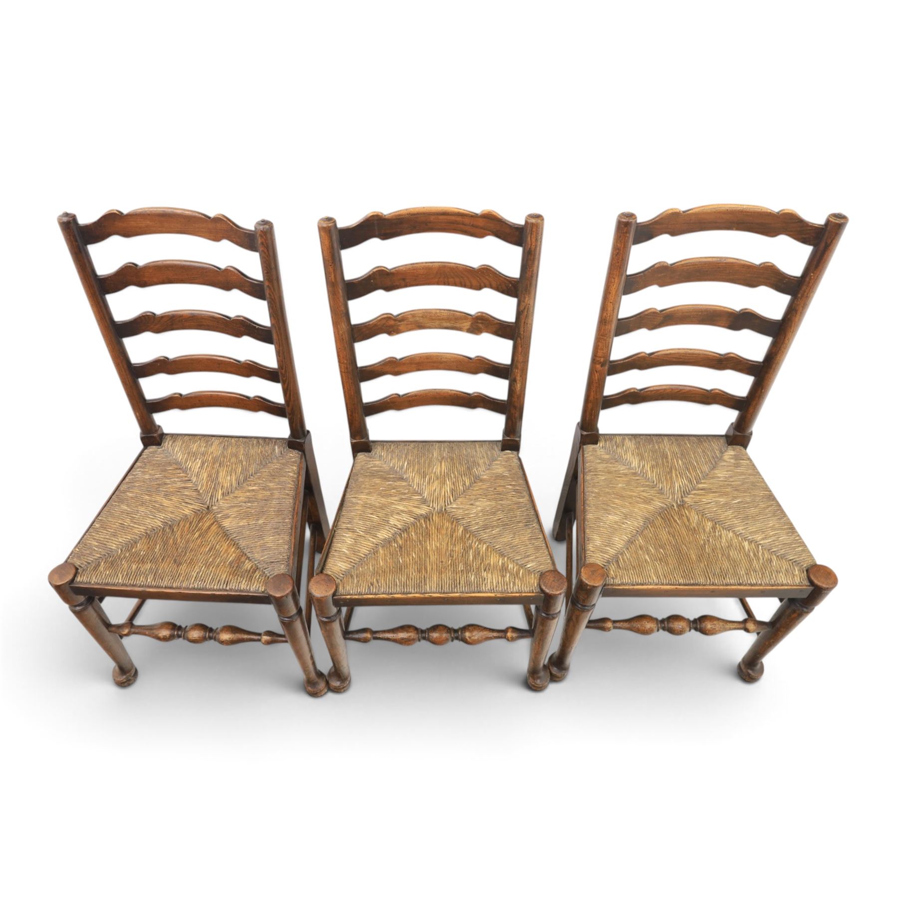 19th century set of six ash and elm ladderback dining chairs, shaped ladder backs above rush seats, raised on turned front supports with pad feet, united by turned stretchers