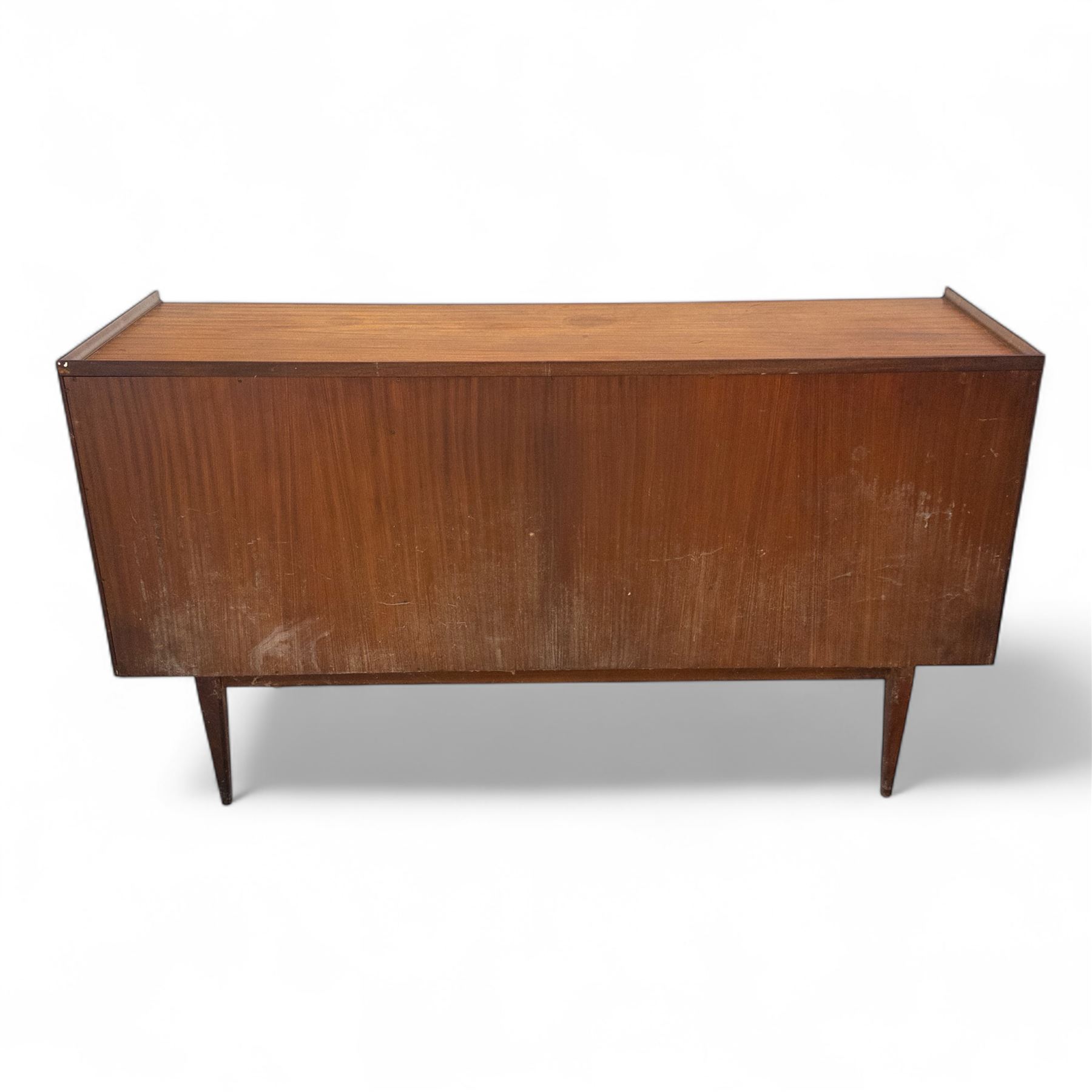 Richard Hornby for Fyne Ladye - mid-20th century afromosia teak sideboard, retailed by Heals of London, rectangular form, with low profile carved gallery lip, above three central drawers with ribbed drawer fronts, flanked by two cupboards with vertically grained doors and recessed pull handles, with streamlined moulded edges and sides, raised on tapered slender legs 