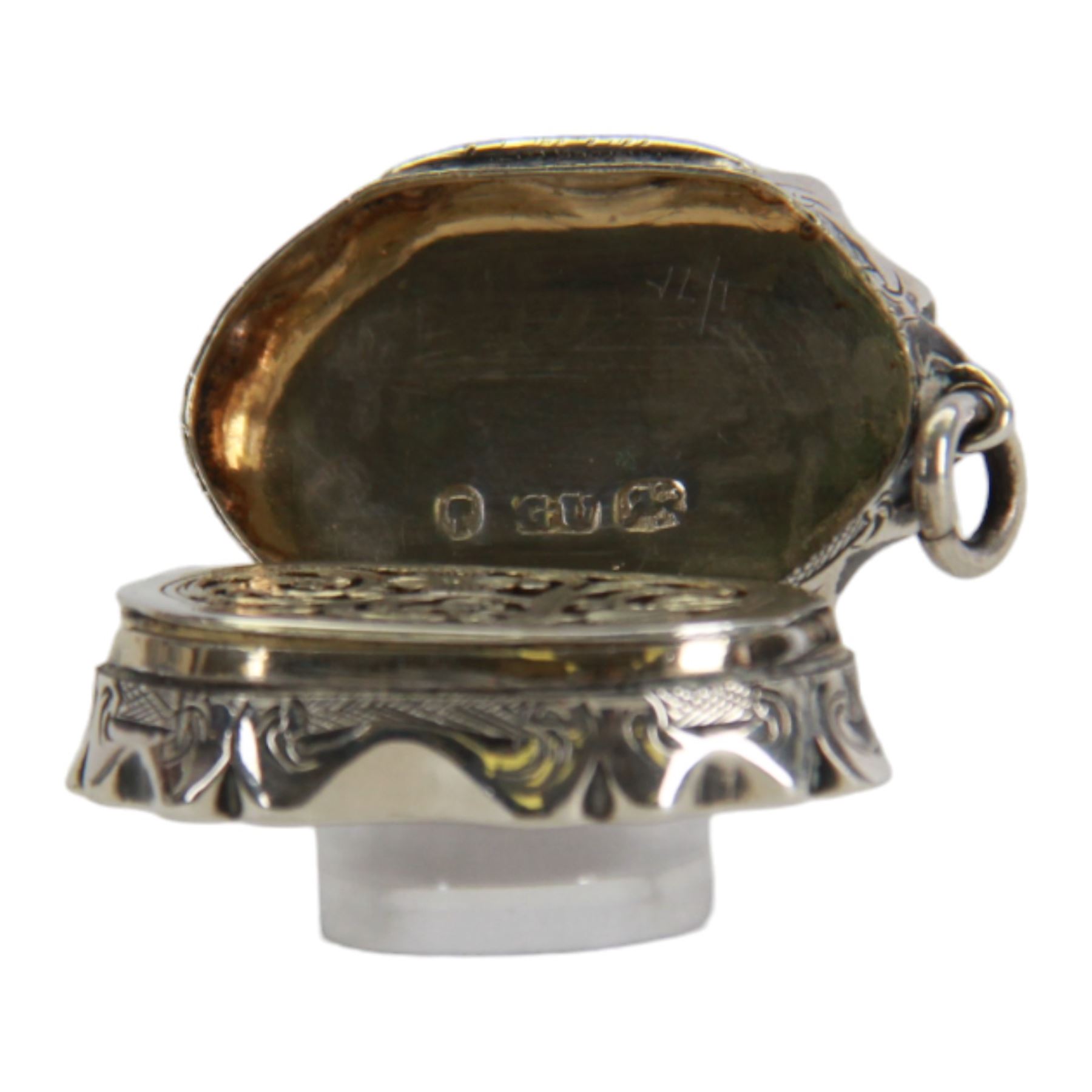 Victorian silver vinaigrette, of oval form with shaped edge, decorated throughout with engine turned bands, the hinged cover with vacant C scroll panel opening to reveal a foliate pierced grille and gilt interior, hallmarked George Unite, Birmingham 1857, L3.5cm