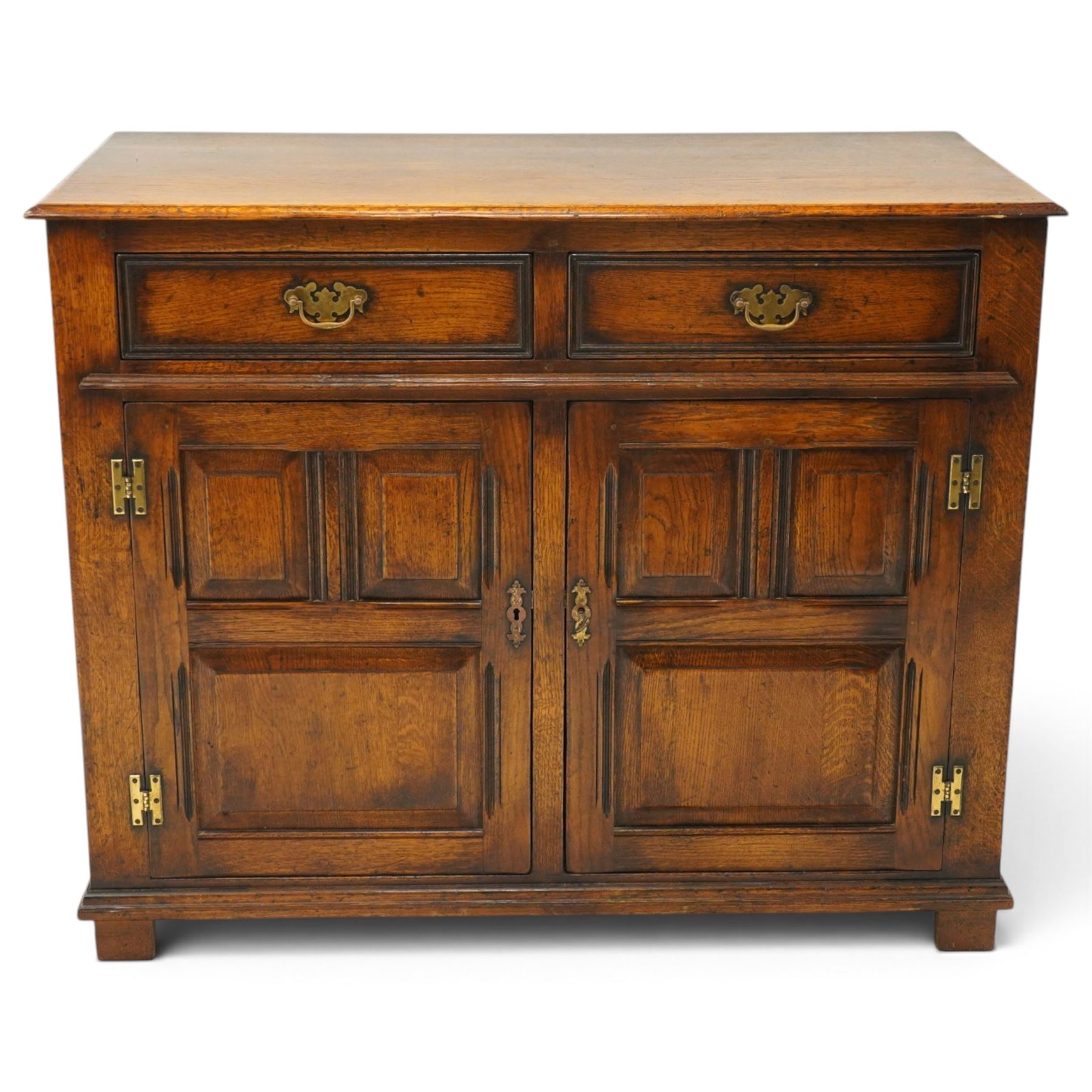 18th century style oak dresser base, rectangular moulded top over two frieze drawers with brass handles, twin panelled cupboard doors below with pierced brass escutcheons, on stile feet