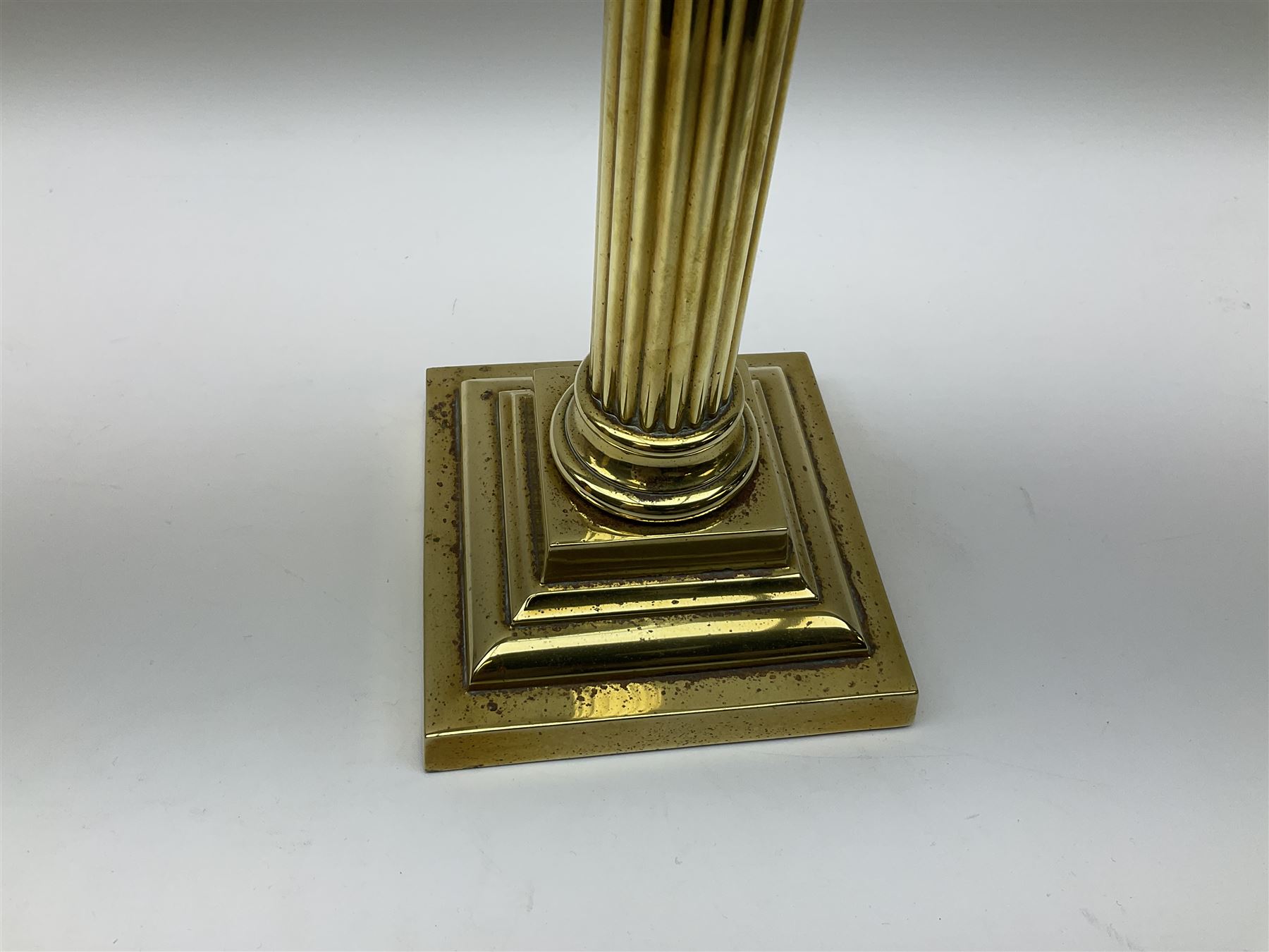 Victorian brass oil lamp, the square stepped base leading to a Corinthian column supporting a part slice cut clear glass reservoir, burner, clear glass chimney and foliate etched glass shade with amber rim, overall H80cm
