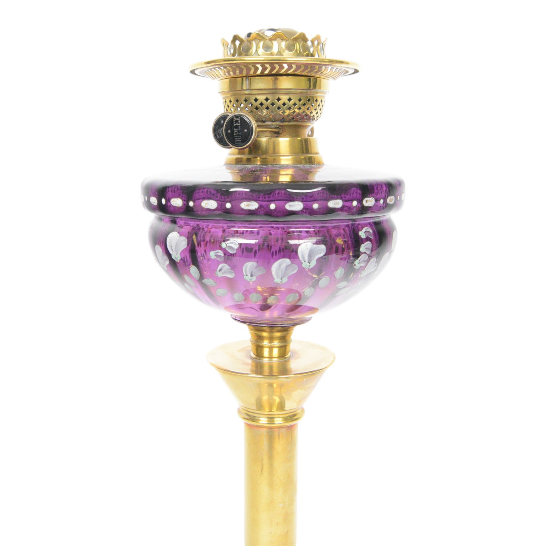 Victorian oil lamp, the brass base supporting a floral enamelled amethyst glass reservoir, duplex burner, and clear glass chimney, overall H69cm