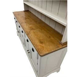 Victorian pine dresser, raised painted three heights plate rack with projecting cornice, waxed top over pained base fitted with three drawers and two double cupboards, bracket feet