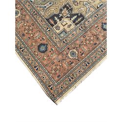 Persian Heriz pale olive and ivory ground carpet, large quatrefoil medallion with palmettes, the surrounding field decorated with trailing leafy branches and stylised plant motifs, peach ground borders with overall floral pattern, within guard stripes 