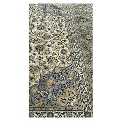 Kashan Persian rug, hand knotted, ivory ground rug, the rosette medallion decorated with projecting palmettes, on a field of swirling leafy branches and decorated with further palmettes, the scrolling border with repeating stylised plant motifs, within floral pattern guard stripes