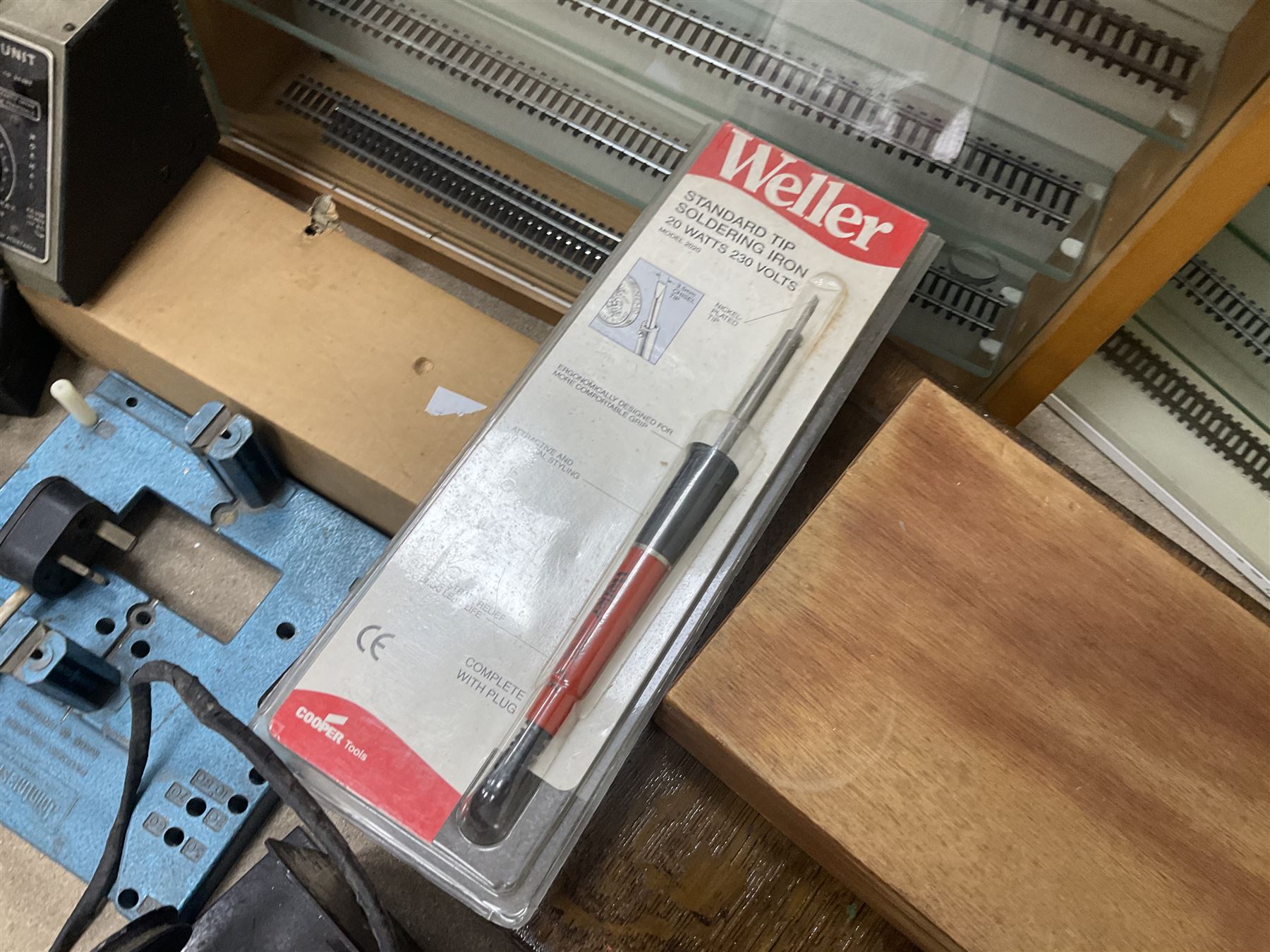 Six shelved cabinets for displaying ‘00’ gauge locomotives comprising plain plywood and white painted examples with track applied to various shelves, largest H63cm, W107cm, D27cm; Collection of tools for building model locomotives to include Weller PU-2D Soldering Pencil and Standard Tip Soldering Iron 20W/230V, Humbrol Modellers Airbrush, Power Supply Units and two wooden chests one of which housing a collection of tools including tweezers, scalping tools, wrenches etc 