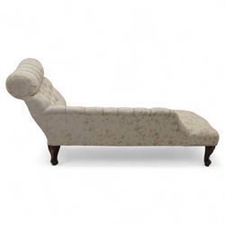 Late 19th century upholstered chaise longue, the gently scrolled headrest above a buttoned back and sprung seat, upholstered in a floral patterned fabric, raised on cabriole mahogany supports with ceramic castors