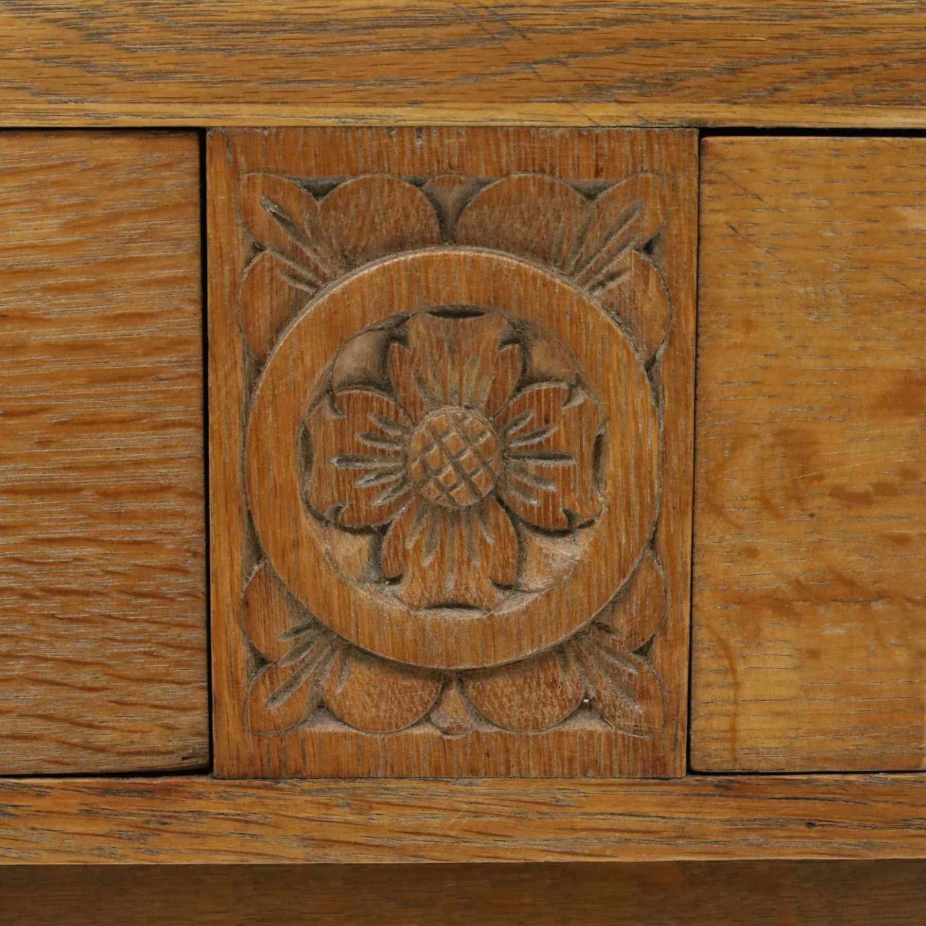 Leemings of Halifax (est. 1872) - Arts & Crafts oak side table, rectangular caddy top with raised moulded back, the frieze carved with central Yorkshire rose motif flanked by two drawers, raised on twin stylised lyre end supports formed of C-scrolls, united by shaped stretcher