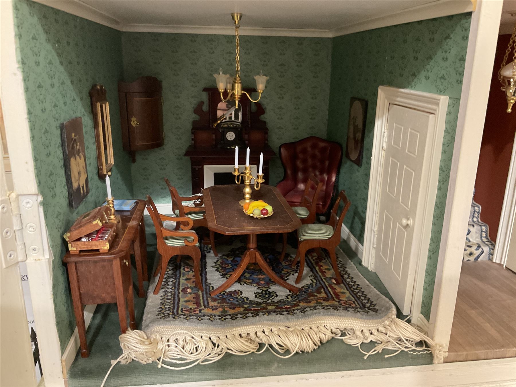 Honeychurch kit-built large wooden dolls house as a 19th century style double fronted four storey town house; with stucco finish under a pitched roof with Palladian style pediment and simulated tiles; protruding front courtyard with railings, street light and steps giving access to two fully furnished basement rooms; central door with Ionic columns and entablature; double hinged front facade opening to reveal a fully furnished interior with hall, stairs and landings and two rooms on each floor; wired for electric wiring W67cm H102cm D58cm