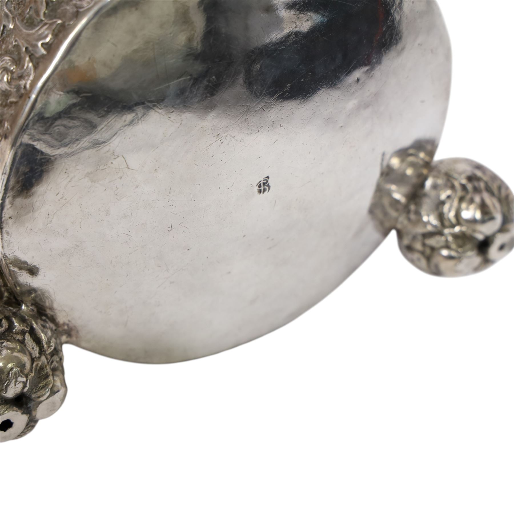 Northern European silver peg tankard, probably late 18th/early 19th century, of cylindrical form, the body repoussé decorated with scrolling and blossoming acanthus, fitted with scroll handle with shield terminal, the hinged cover with conforming repoussé decoration surrounding a central circular panel engraved with monogram beneath initials EASBGD, opening with ball thumbpiece detailed with fruits, raised upon three confirming ball feet mounted with shaped panels also detailed with fruits, bearing indistinct mark beneath, H19cm