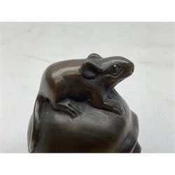Netsuke in the form of a rat sitting on a skull, signed to the base