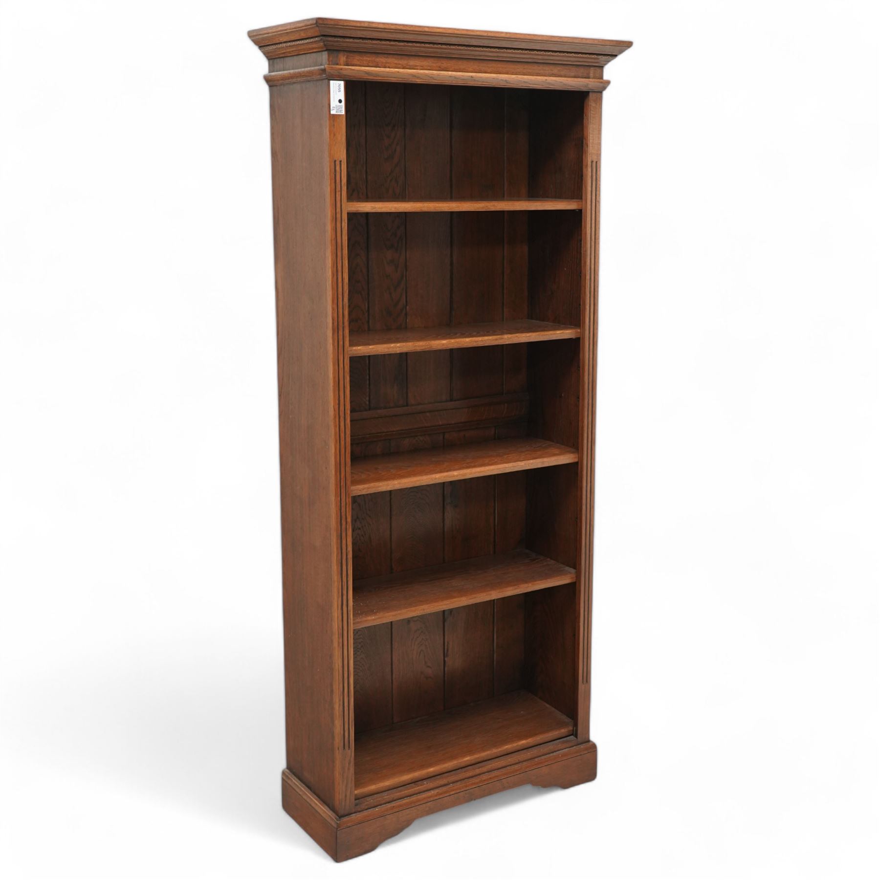 Oak open bookcase, projecting cornice over open front fitted with adjustable shelves, fluted uprights, on shaped bracket feet 