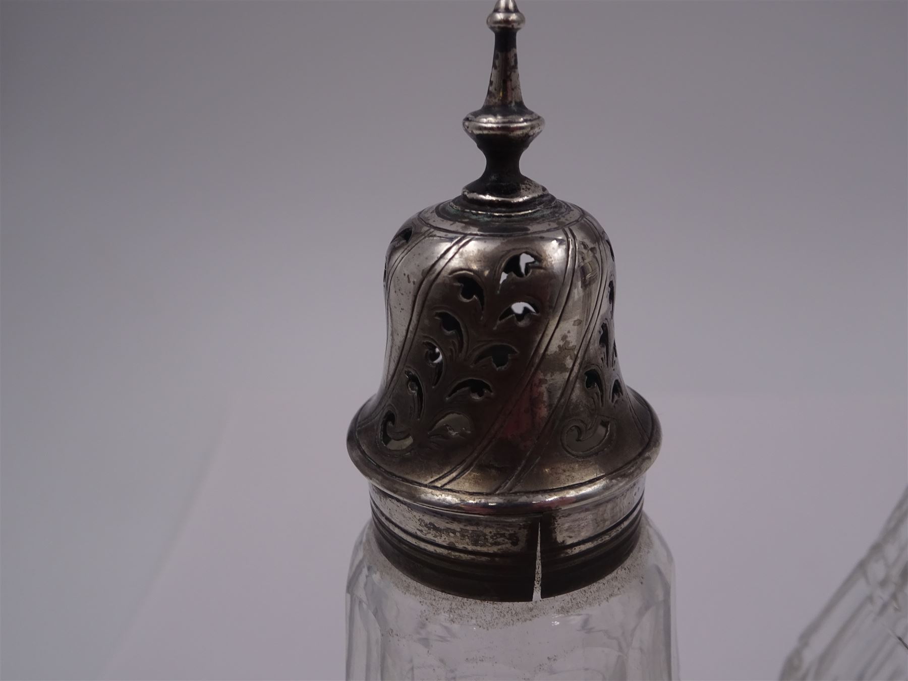 Late 18th century silver cruet stand, of oval form, with pierced sides upon four bun feet, hallmarked to handle Hester Bateman, all other hallmarks indistinct, together with five matched silver mounted cut glass cruet bottles, including some later Victorian examples, hallmarks predominantly indistinct, stand H20cm