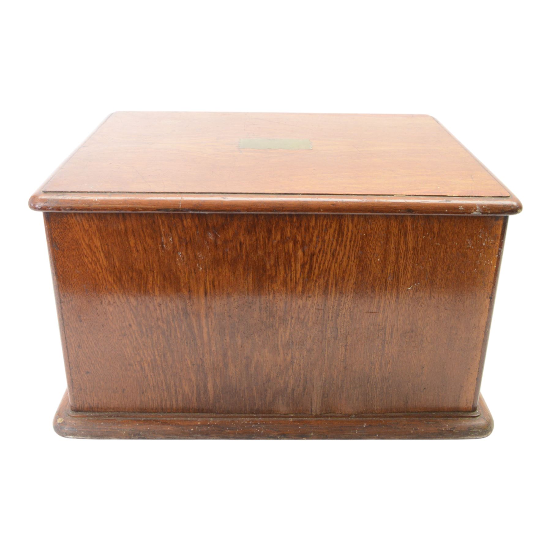 Oak table top canteen cabinet, the top with inset vacant brass cartouche, with pair of panelled doors opening to reveal four interior drawers with inset brass handle, containing a selection of silver plated flatware, 29cm x 40cm x 51cm