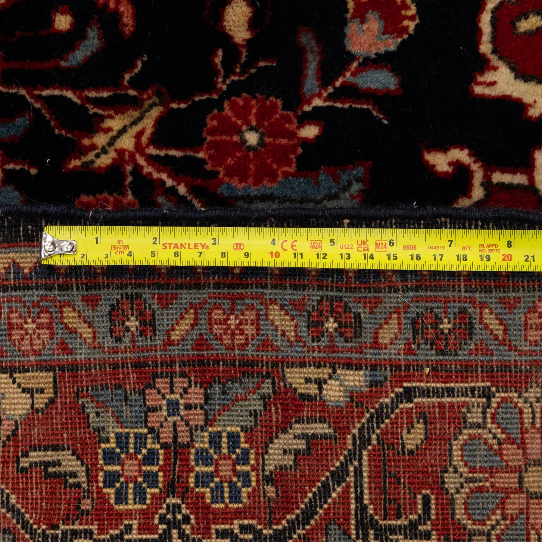 Two hand-knotted rugs, comprising Persian floral rug, dark blue ground decorated with scrolling foliage and flowerheads within a red floral border (H 208cm, W 134cm); Bokhara type rug, red ground with repeating gul motifs and geometric guard borders (H 174cm, W 94cm)