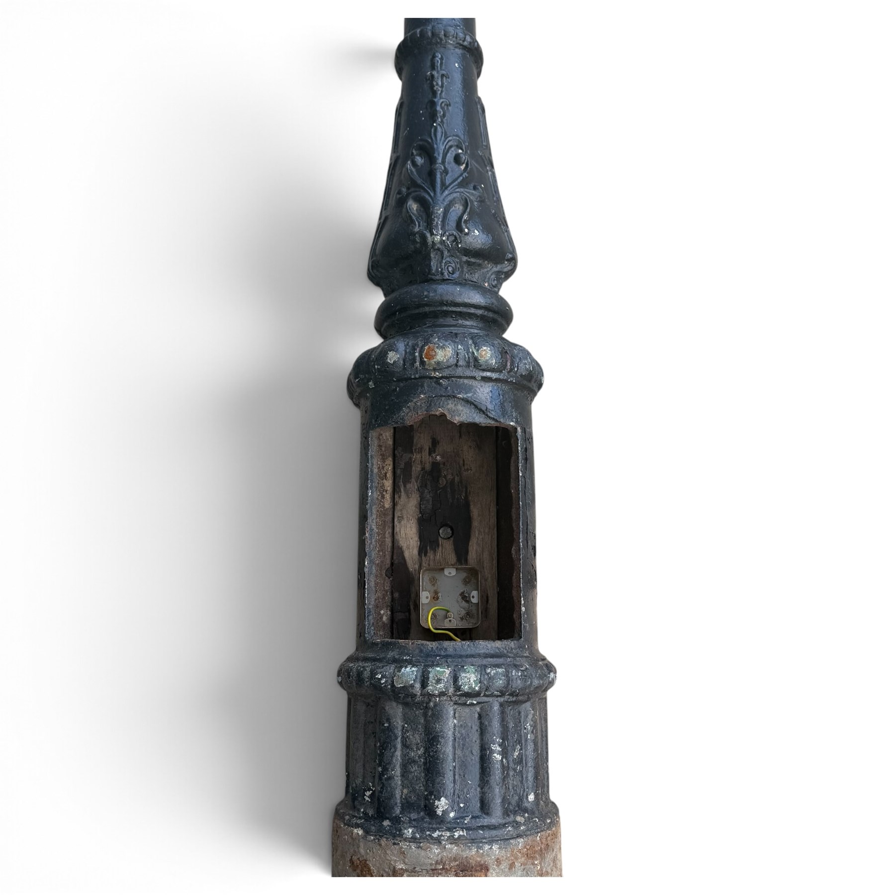 REVO Electric Co. Ltd., Tipton - early 20th century cast iron street lamp standard, the later hexagonal lantern with amber leaded glazing and pointed finial, supported on a swan-neck bracket above a ring-turned capital, tapering column and ladder rest, terminating in a moulded scrolling foliate-decorated base with lappet collar, stamped REVO

Provenance: formerly installed as street lighting in Prestwich, Greater Manchester
