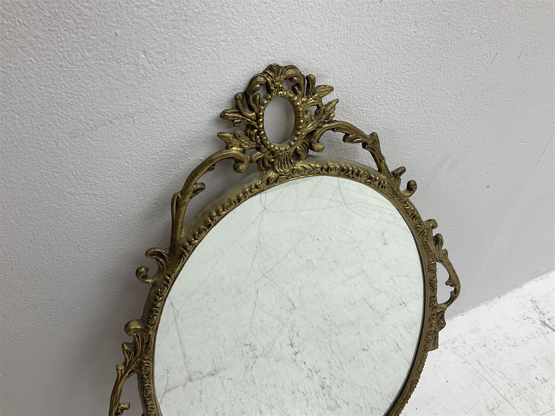 Ornate brass wall mirror with oval plate, L78cm