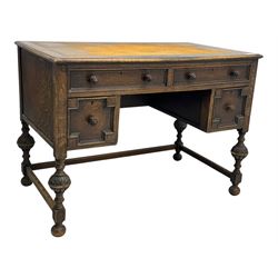 Early 20th century Jacobean design oak desk, with rectangular top inset with worn tooled leather, two frieze drawers over pedestals each fitted with a pair of panelled drawers, turned handles, on carved and fluted tapering legs united by stretchers 