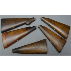  Five walnut gunstocks, each fitted with an eye hook for wall display  