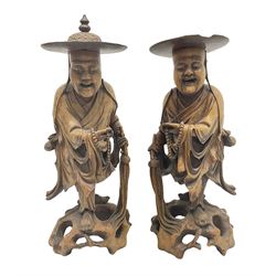 Pair of Japanese carved wooden figures, modelled as merchants in traditional dress, upon pierced naturalistic bases, tallest H39cm