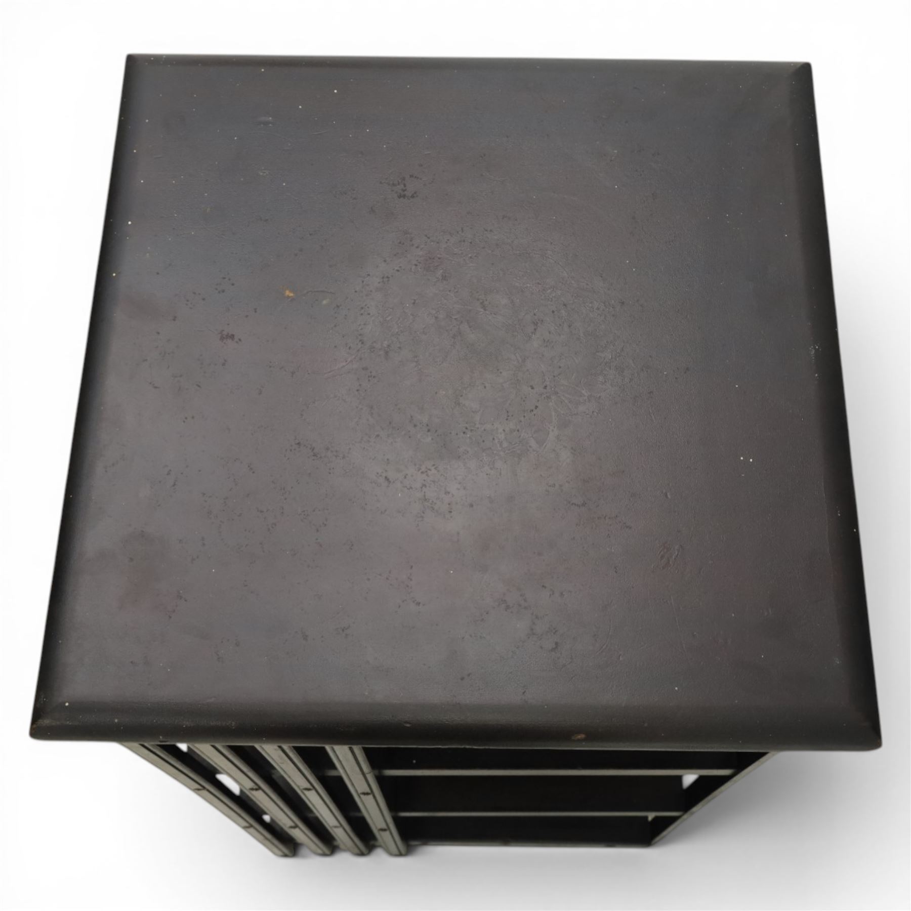 20th century ebonised revolving bookcase, square top with chamfered edges, over a three tier with four sections per tier,  revolving base on castors 