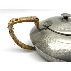 Liberty & Co Tudric pewter three piece tea service, comprising teapot with woven reed handle, twin handled open sucrier, and milk jug, each of squat form with planished finish, each impressed beneath Tudric Pewter Ware 01537 Made in England