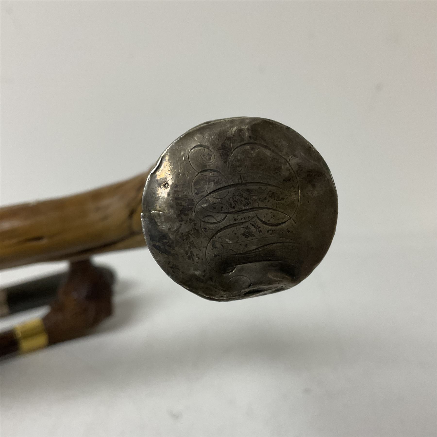 19th century painted bamboo walking cane, the handle carved as a fox with glass eyes, with gilt metal stamped LB, together with an ebonised wooden walking stick, with horn pommel and hallmarked silver collar and a curved wooden walking stick, with monogrammed white metal cap, tallest L90cm